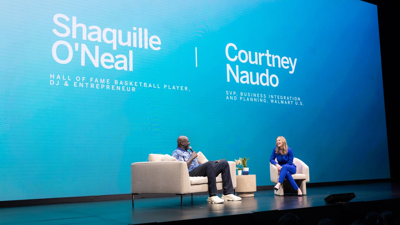 Shaquille O’Neal in conversation with Walmart’s Courtney Naudo on the Walmart × VIZIO NewFront 26 stage, their names on the screen behind them
